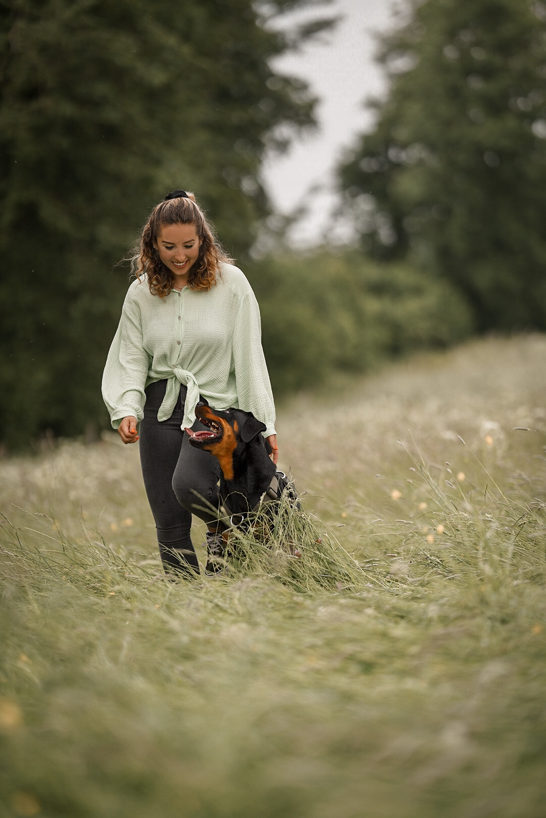 Frau mit Hund spazieren im Feld im Blackpack Hundegeschirr